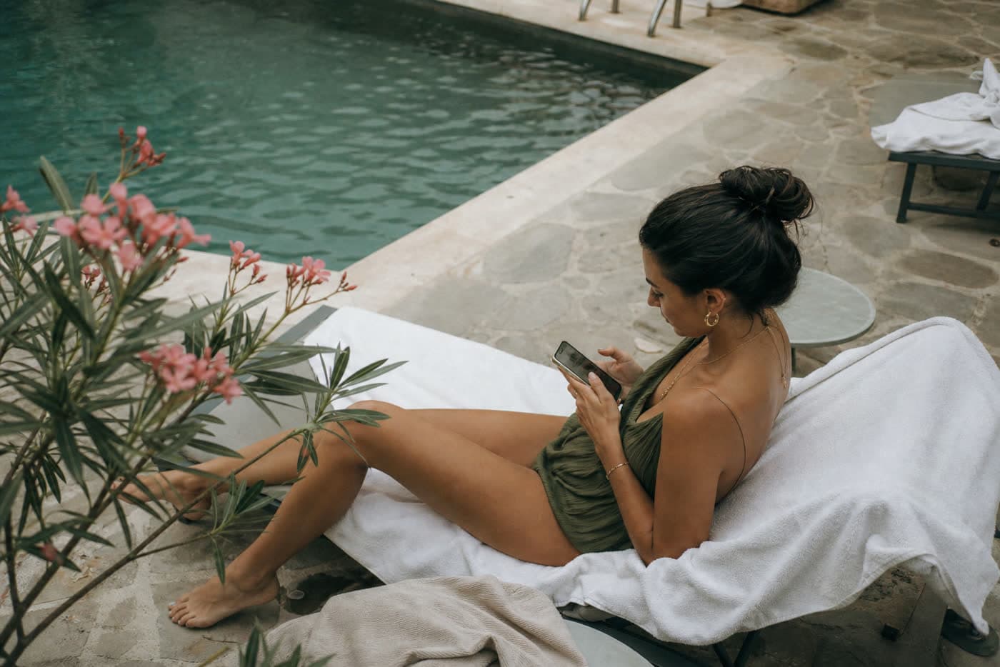 Huésped junto a la piscina del hotel pidiendo extender la estancia