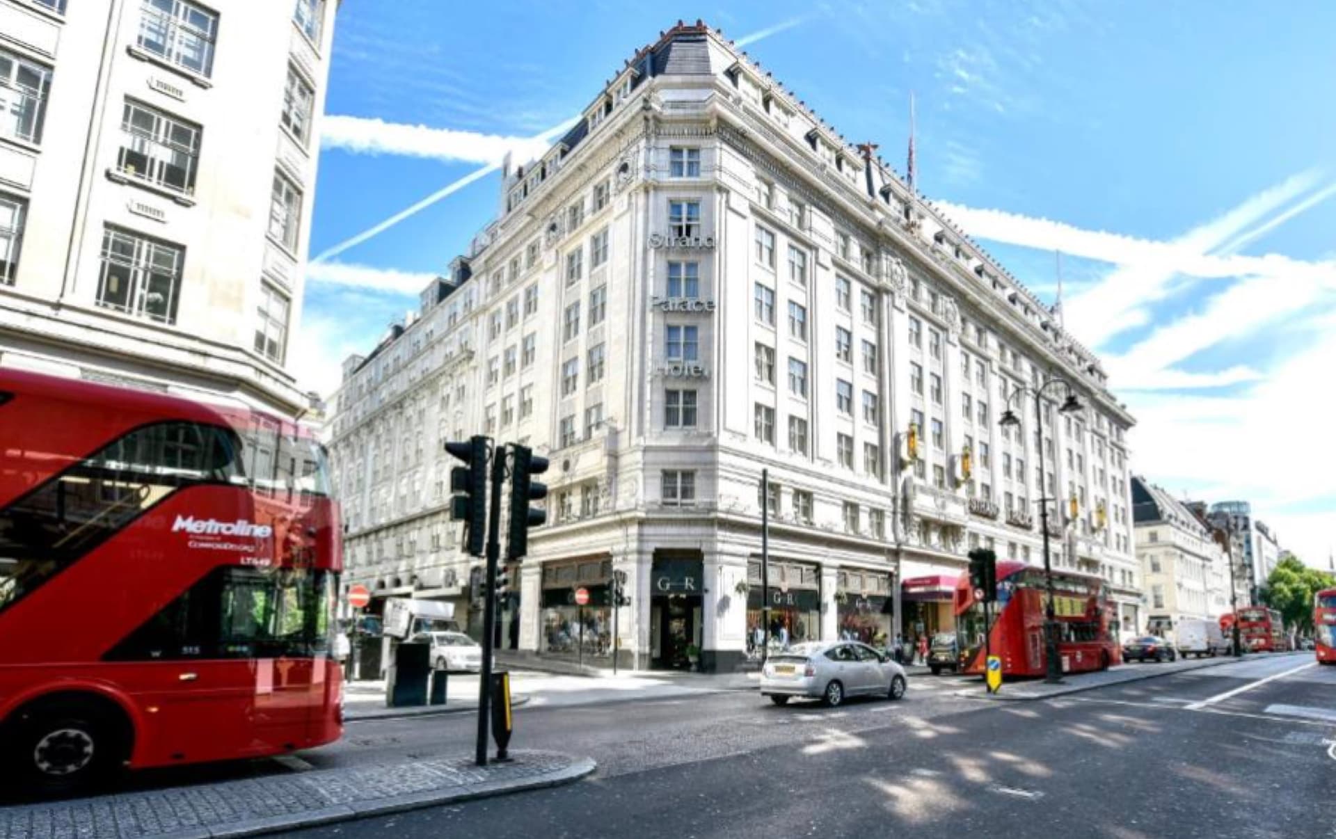 Strand Palace Hotel corner exterior on the Strand, London, with red double-decker buses