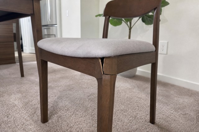 Dining chair with a visible crack along the front leg joint
